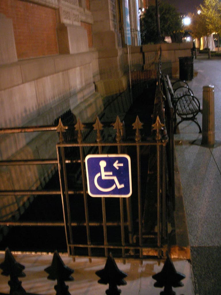 Accessible entrance sign near a ramp